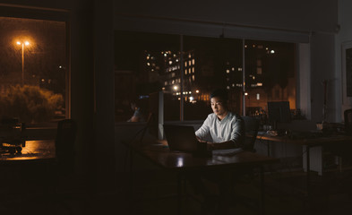 Asian businessman working at his desk late in the evening
