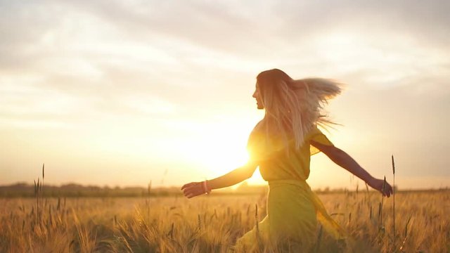 Young beautiful girl in red dress in the field at sunset. Slow motion. HD