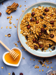 Homemade granola with honey, raisins, cherries, sesame and chestnuts on blue