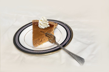 Pumpkin pie slice on plate with fork