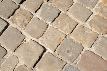 The road in the city is enclosed with an old pavement. Top view on the pavement is close up