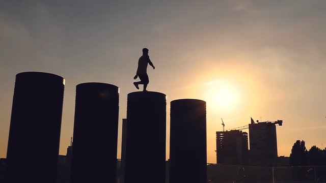 Silhoutte of young man jumping from trunk. Street style. Slowmotion.