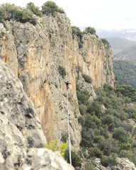 Highliner on a rope. Highline on a background of mountains. Extreme sport on the nature. Balancing on the sling. Equilibrium at altitude.