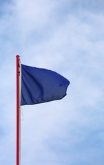 big blue flag waves on the sky