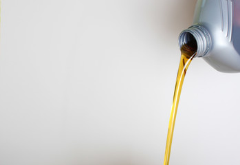 automotive oil in a hand a gray bottle on a light background