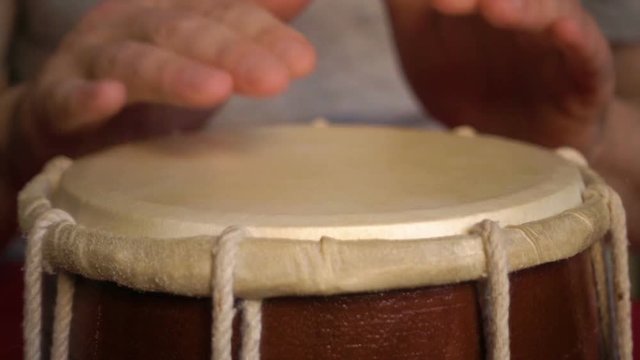 Close up of hands of a man playing a drum. Slow Motion.