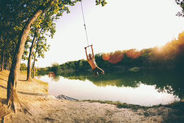 A man is riding a makeshift swing.
