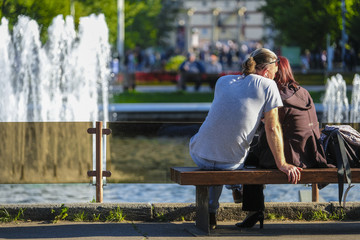 Moscow, Russia - September, 15, 2018: people sit on a bench in Moscow park Sokolniki