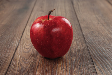 Red apple with water drops on the wooden surface
