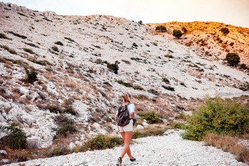 Hiker woman with backpack on trekking trail, travel and active lifestyle concept