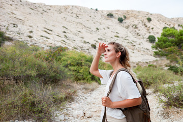 Hiker woman with backpack on trekking trail, travel and active lifestyle concept