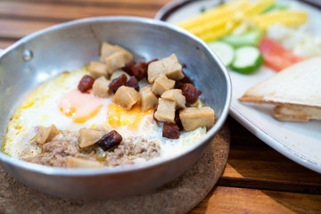 Close up breakfast food in Thai style ,Indochina pan-fried egg with pork and toppings ,salad .Selective focus ,vintage tone