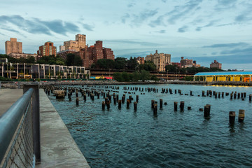 Obraz premium Brooklyn waterfront from Pier 1, with some submerged poles in the foreground (New York, USA)