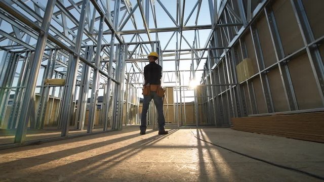 The Construction Site. Steel Frame of the Building and Contractor Worker.