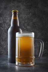 Bottle of cold beer and glass mug with foam