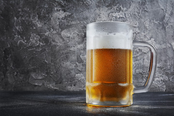 Single glass mug of cold beer with foam