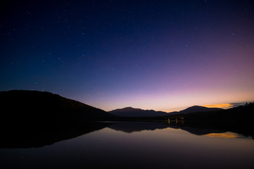 Stunning reflection starts and the mountain on the lake after sunset.