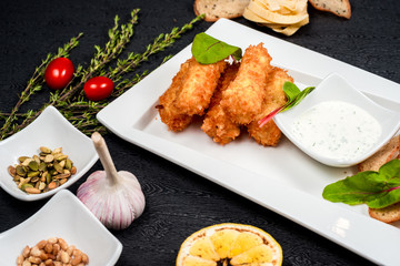 tasty cheese sticks with bread crumbs on a white plate