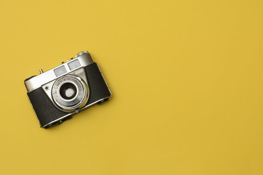 old retro camera on yellow background composition