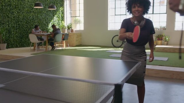 young black business people playing ping pong in office enjoying competitive fun colleague using smartphone sharing game on social media taking video