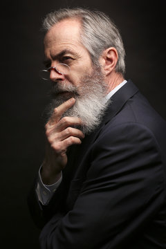 mature male model wearing suit with grey hairstyle and beard