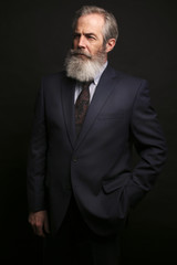 mature male model wearing suit with grey hairstyle and beard