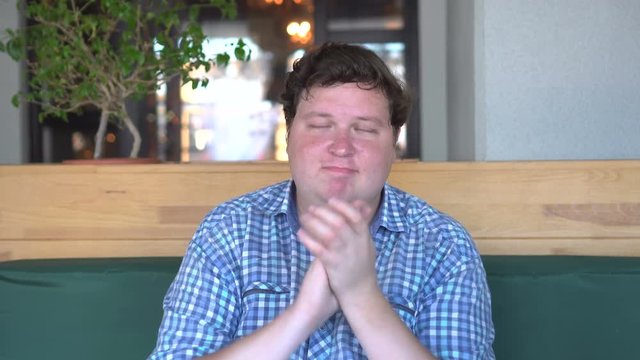 Fat man claps and applauding in cafe or restaurant