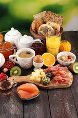 breakfast on table with bread buns, croissants, coffe and juice.