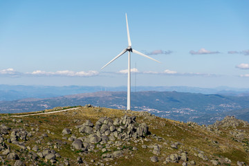 eolic renewable energy with wind turbines next to little chapel on a cloudy ble sky
