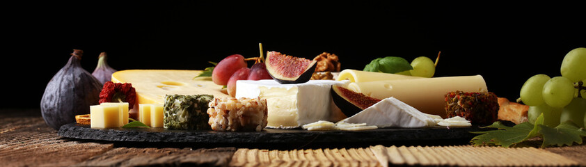 Cheese platter with different cheese and grapes.
