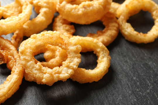 Homemade crunchy fried onion rings on table, closeup