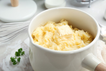 Saucepan with tasty mashed potato on table, closeup