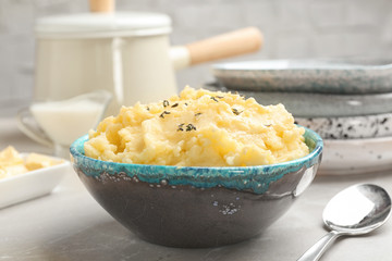Bowl with tasty mashed potato on gray table