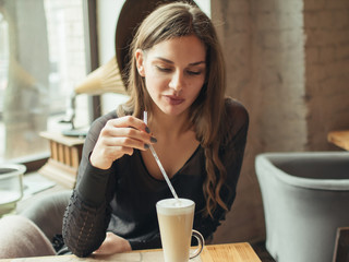 Young woman drinking coffee in a cafe .