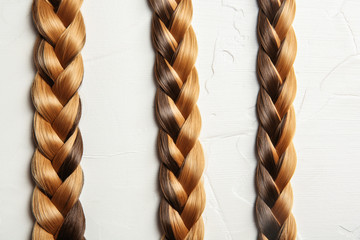 Flat lay composition with braids on light background. Healthy hair