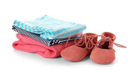Stack of child clothes and cute shoes isolated on white