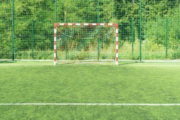 Empty mini football goals on the artificial field with green grass