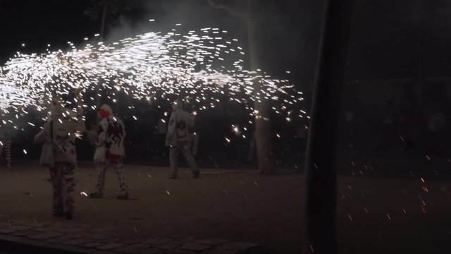 Traditional correfoc performance. In the correfoc, a group of individuals will dress as devils or Diables and light fireworks - fixed on devil's pitchforks or strung above the route