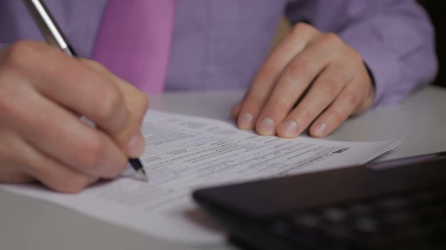 Man filling US tax form. tax form us business income office hand fill concept. Closeup.  Man Is Checking The Box Of Filing Status In The US Individual Income.  Tax Return Form 1040