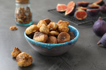Bowl with delicious dried figs on grey table. Organic snack