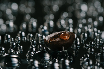 shiny fresh roasted coffee macro beans on glass background with water drops