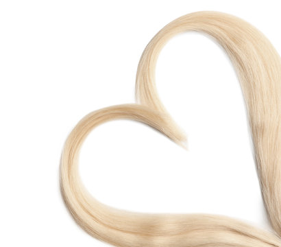 Heart made of blond hair locks on white background