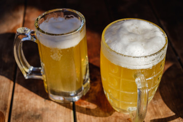 Close-up two cold beers with foam and drops.