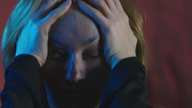 4k, slow motion, Halloween. tired woman in the costume of a terrible witch, erases the make-up from her face with her hands. close-up