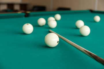 Russian billiard table with balls and cue sticks on a green background.