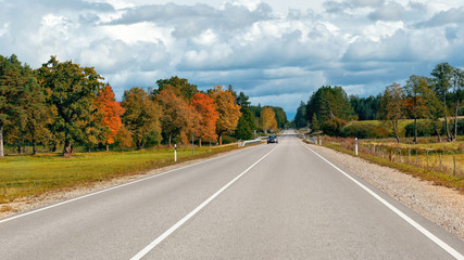 Autumn landscape with asphalt road and forest.