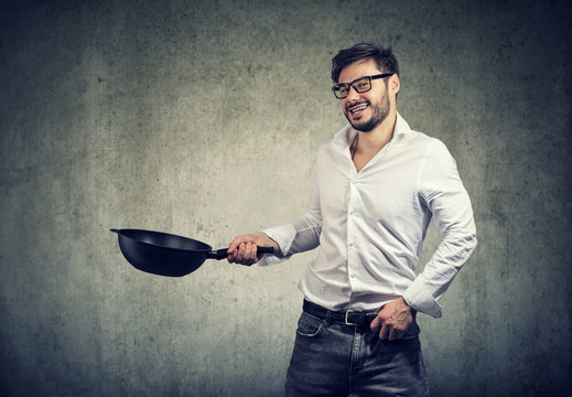Excited man cooking with frying pan