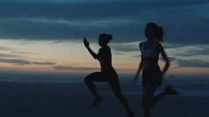 silhouette of women running sprinting on beach athletes training intense cardio enjoying competitive workout challenge early morning run - Powered by Adobe
