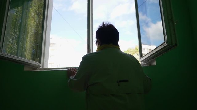 an elderly woman looking out the window MLS 3