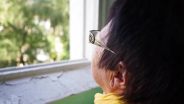 an elderly woman looking out the window BCU